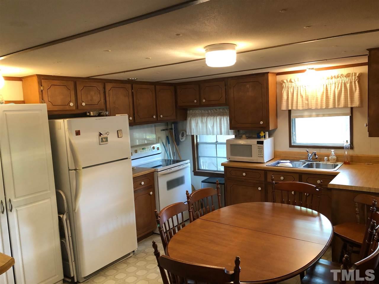 9546-9548 George Ruff Road Bullock, NC 27507 - Photo 8 of 25 a kitchen with refrigerator a stove a sink and chairs