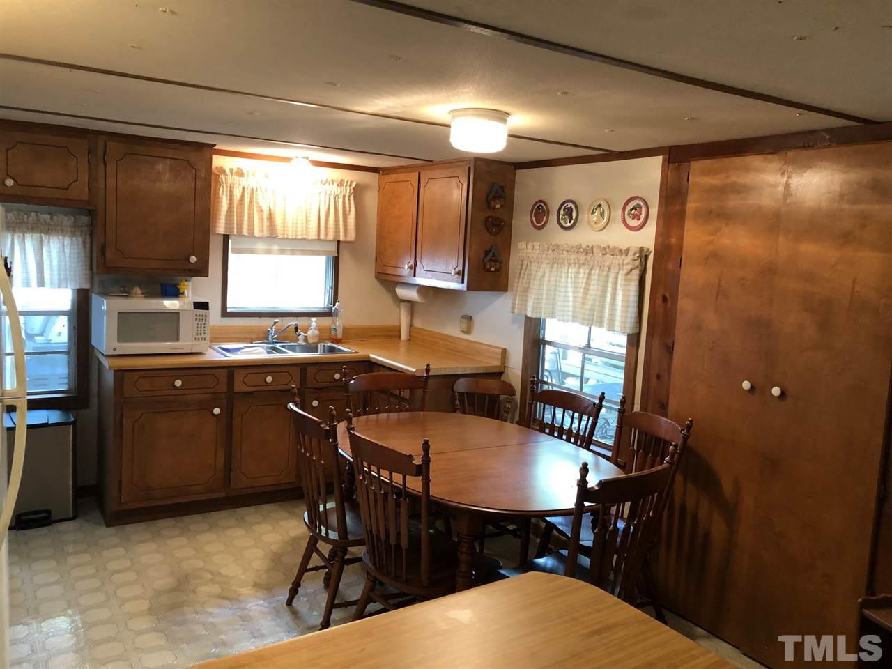 9546-9548 George Ruff Road Bullock, NC 27507 - Photo 9 of 25 a kitchen with a table chairs sink and cabinets