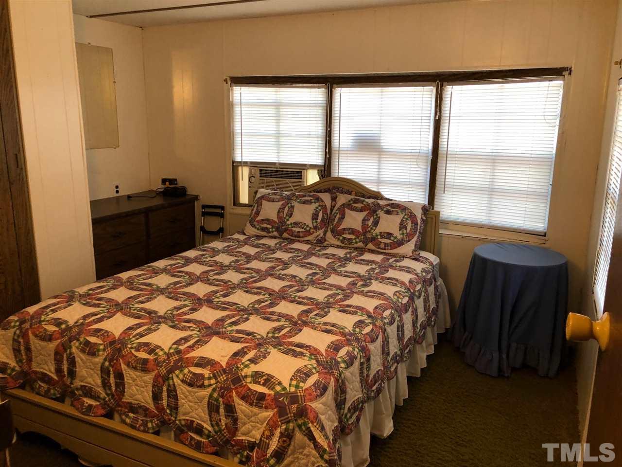 9546-9548 George Ruff Road Bullock, NC 27507 - Photo 10 of 25 a large bed sitting in a bedroom next to a window