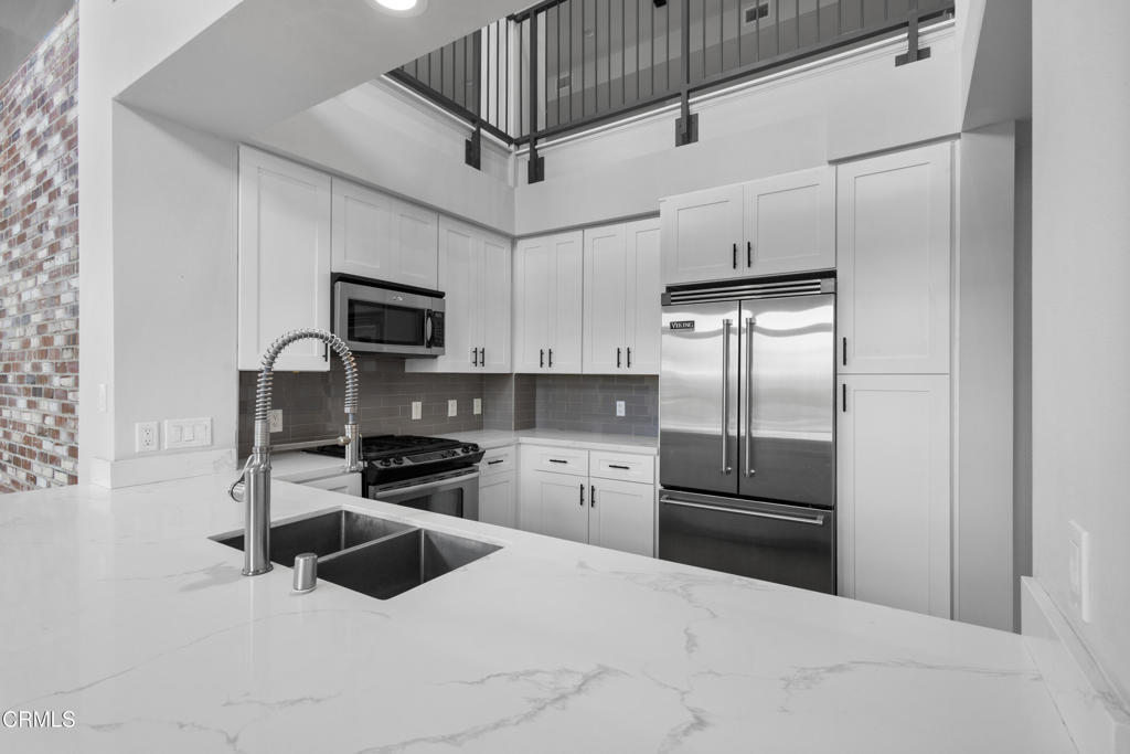 1901 South Victoria Avenue, Unit 204 Oxnard, CA 93035 - Photo 11 of 40 a kitchen with granite countertop a refrigerator oven a sink and dishwasher