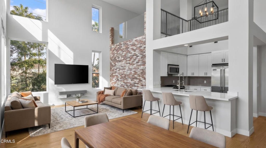 1901 South Victoria Avenue, Unit 204 Oxnard, CA 93035 - Photo 16 of 40 a living room with furniture a flat screen tv and kitchen view