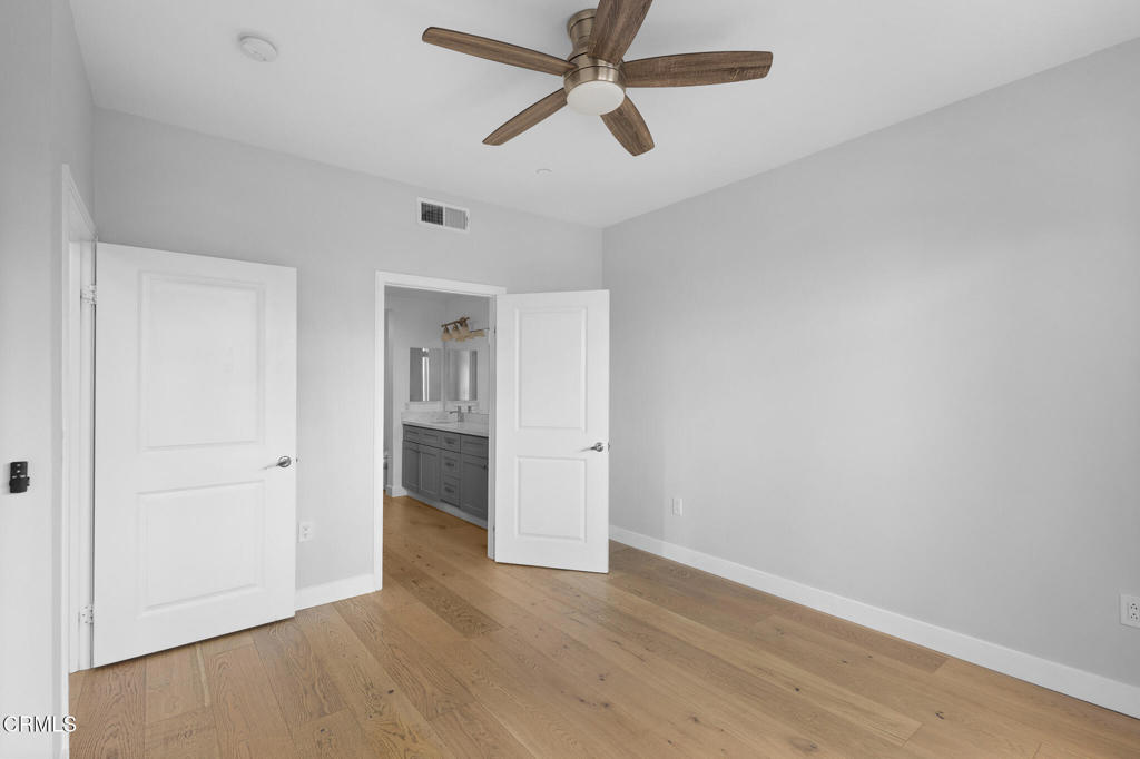 1901 South Victoria Avenue, Unit 204 Oxnard, CA 93035 - Photo 20 of 40 an empty room with wooden floor ceiling fan and windows