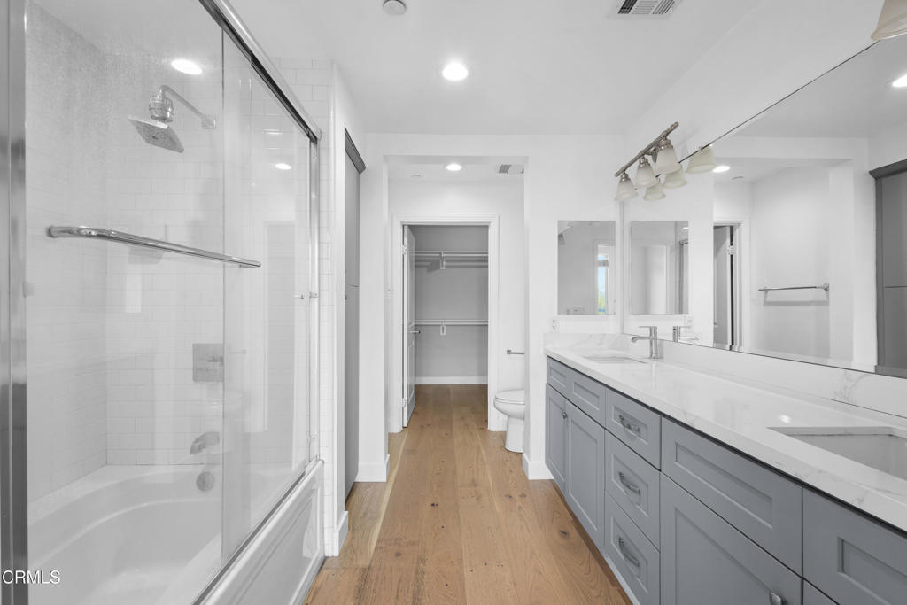 1901 South Victoria Avenue, Unit 204 Oxnard, CA 93035 - Photo 21 of 40 a spacious bathroom with a granite countertop sink a toilet a mirror and shower