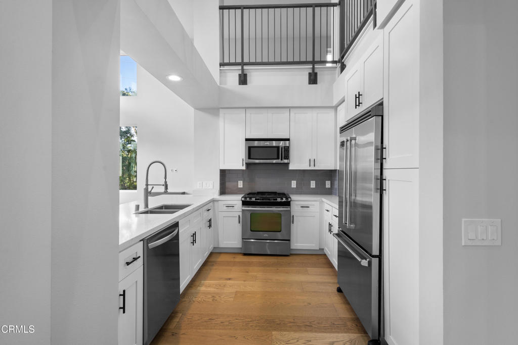 1901 South Victoria Avenue, Unit 204 Oxnard, CA 93035 - Photo 10 of 40 a large kitchen with stainless steel appliances granite countertop a stove and a sink