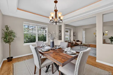 a kitchen with stainless steel appliances granite countertop a stove a sink a refrigerator a dining table and chairs