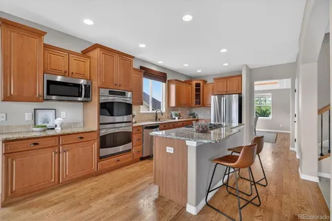 a kitchen with stainless steel appliances granite countertop a refrigerator stove and sink