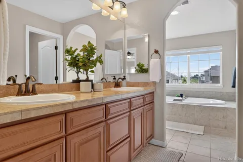 a bathroom with a tub sink and mirror