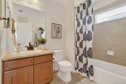 a bathroom with a double vanity sink a toilet a mirror and shower