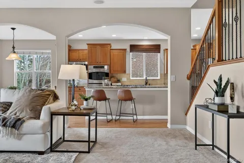 a living room with furniture a fireplace and a floor to ceiling window