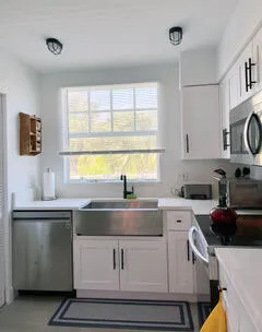 a kitchen with granite countertop a sink and a stove top oven