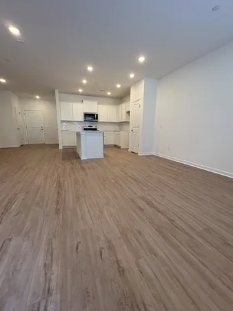 a view of kitchen with kitchen island wooden floor center island and stainless steel appliances