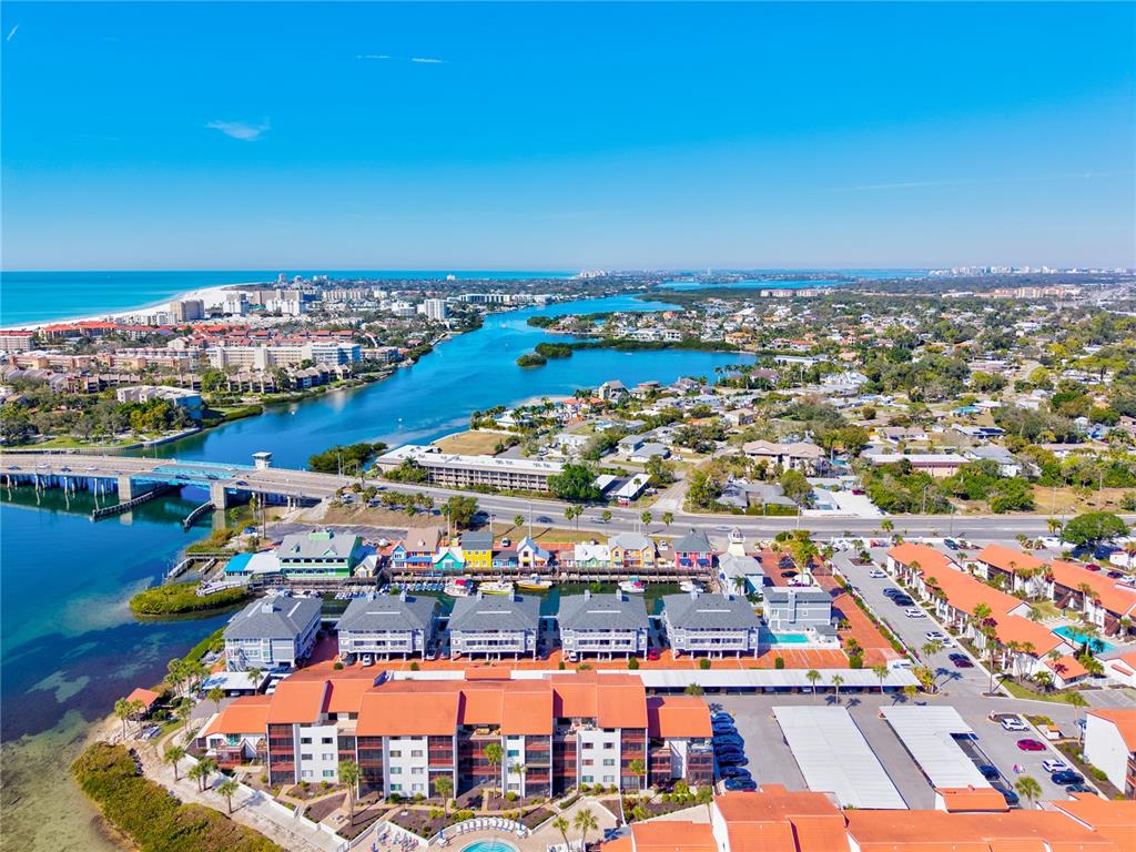 1602 Stickney Point Road, Unit 307 Sarasota, FL 34231 - Photo 40 of 56 an aerial view of a city with lots of residential buildings ocean and mountain view in back