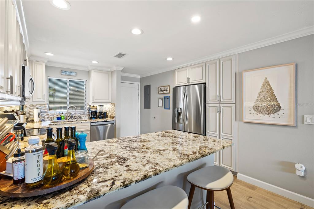 1602 Stickney Point Road, Unit 307 Sarasota, FL 34231 - Photo 6 of 56 a view of a kitchen with kitchen island a large counter top space and stainless steel appliances