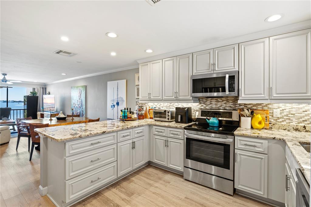 1602 Stickney Point Road, Unit 307 Sarasota, FL 34231 - Photo 7 of 56 a kitchen with a sink stove and cabinets