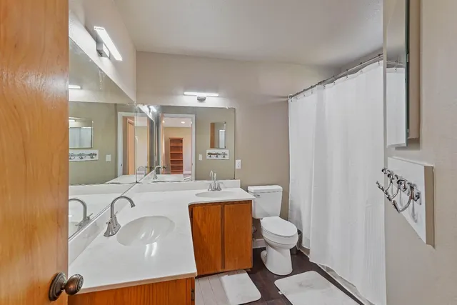 a bathroom with a granite countertop sink mirror vanity and toilet