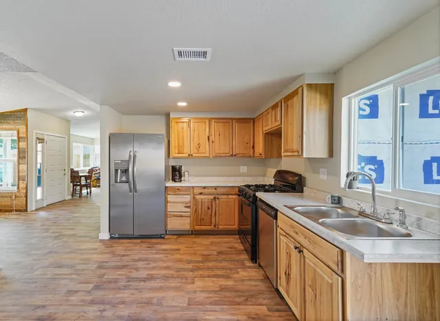 a kitchen with stainless steel appliances granite countertop a sink stove and refrigerator
