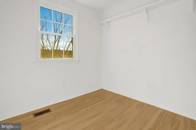 an empty room with a window and a fan