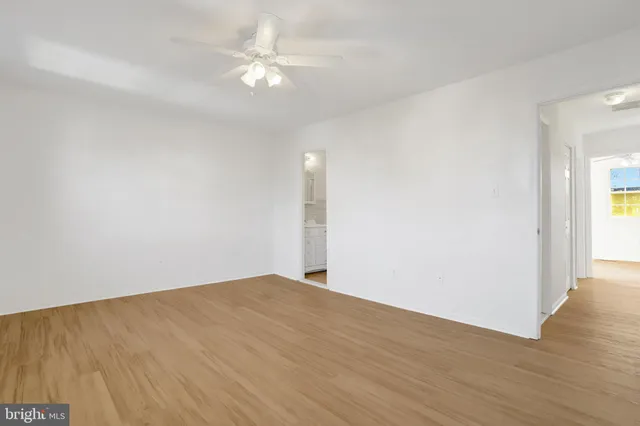 a view of an empty room with furniture and a window
