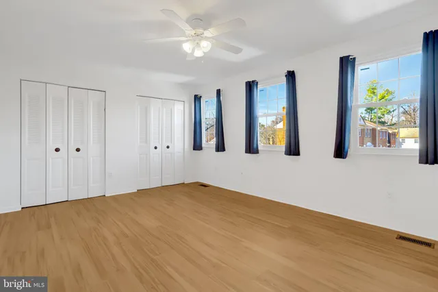 a view of an empty room with wooden floor and cabinet