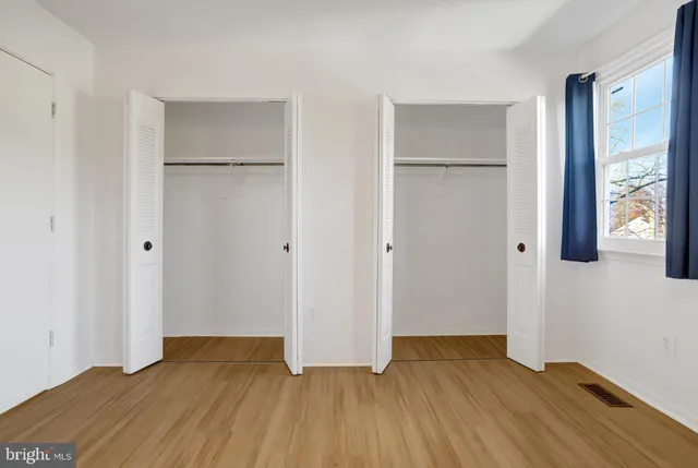 a view of an empty room with a fireplace and a window