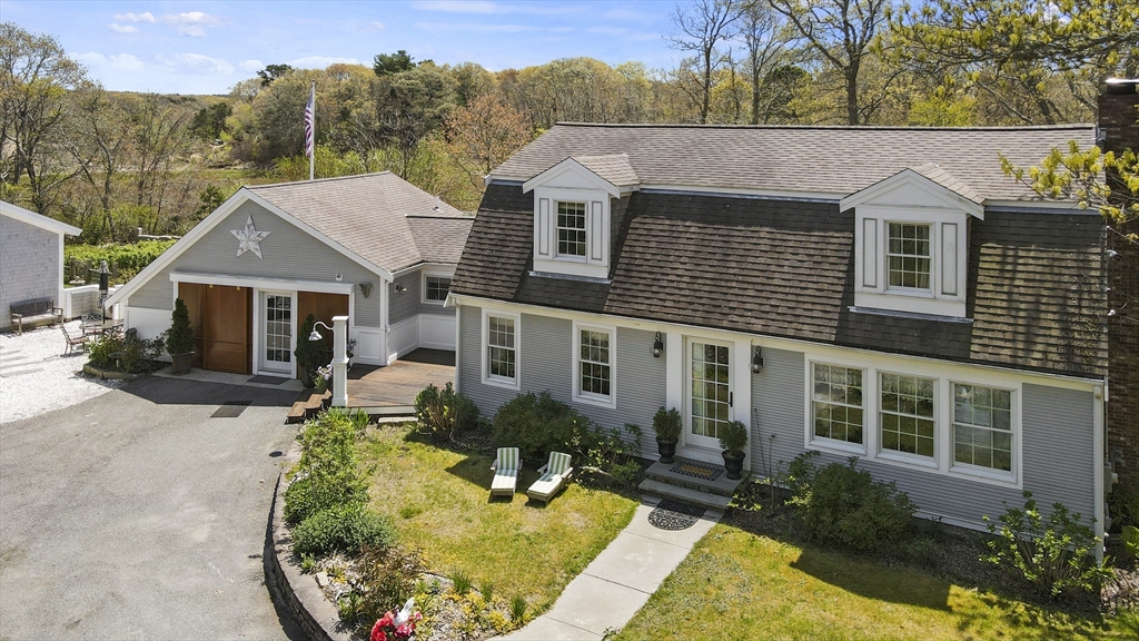 29 Back River Road Bourne, MA 02532 - Photo 2 of 37 front view of a house with a yard table and chairs