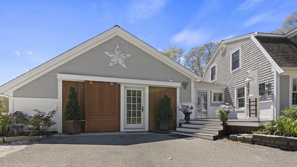 29 Back River Road Bourne, MA 02532 - Photo 4 of 37 a front view of a house with a garden