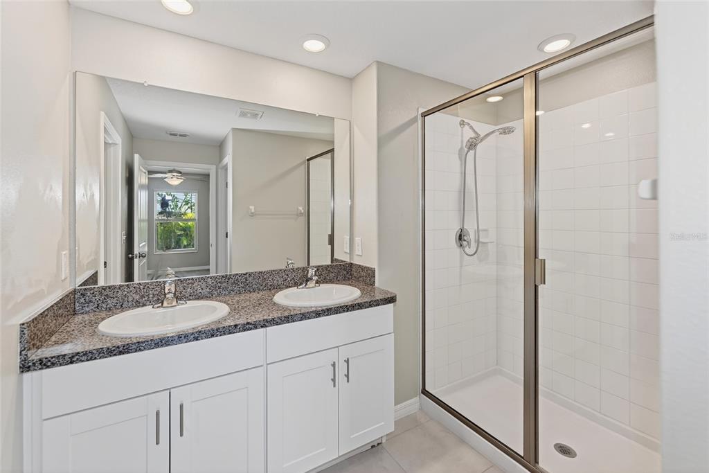 16751 Delia Street Wimauma, FL 33598 - Photo 11 of 36 a bathroom with a granite countertop sink mirror and double
