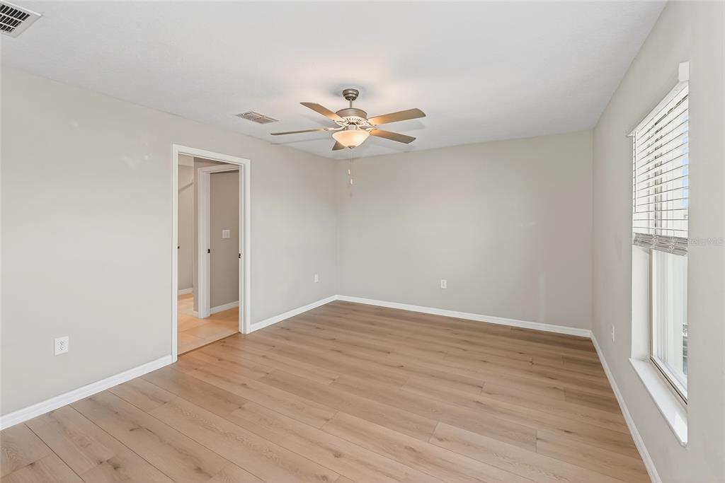 16751 Delia Street Wimauma, FL 33598 - Photo 9 of 36 wooden floor in an empty room with a window