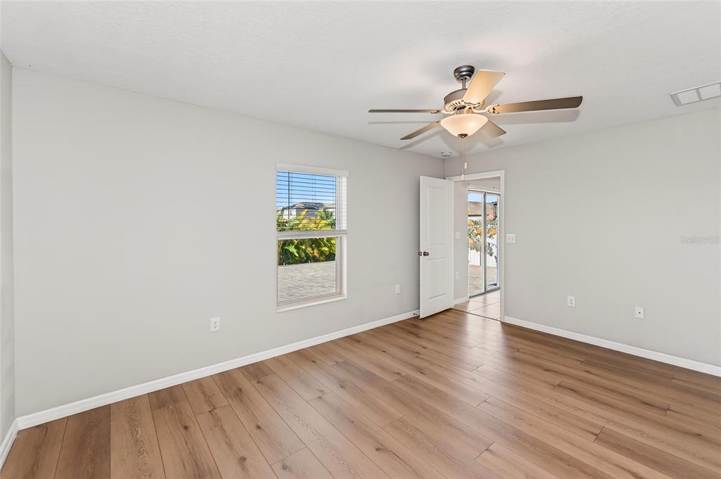 16751 Delia Street Wimauma, FL 33598 - Photo 10 of 36 a view of an empty room with window and wooden floor