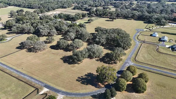 an aerial view of a house with a yard and pool