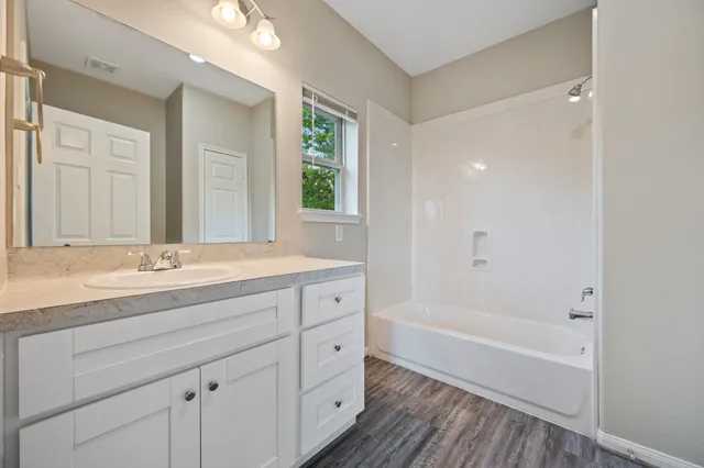 a bathroom with a tub a sink and mirrors