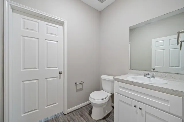 a bathroom with a white toilet a sink and vanity