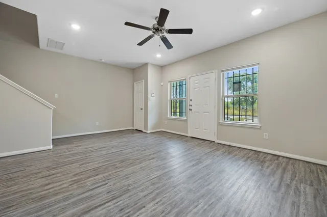 a view of an empty room with a window and a ceiling fan