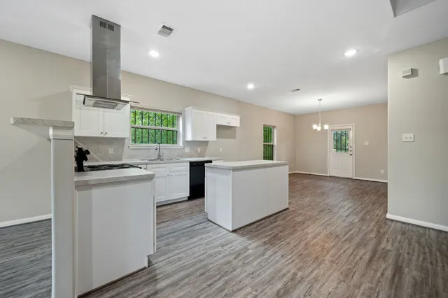 a kitchen with cabinets and wooden floor