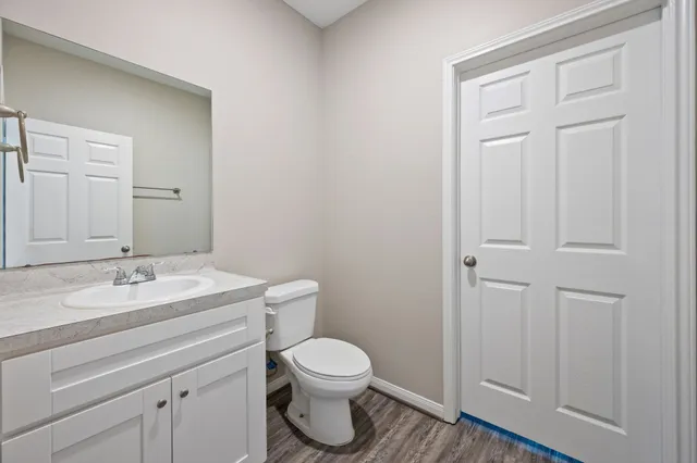 a bathroom with a granite countertop toilet and sink