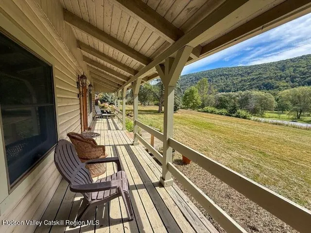 a living room with stainless steel appliances furniture a fireplace and a flat screen tv