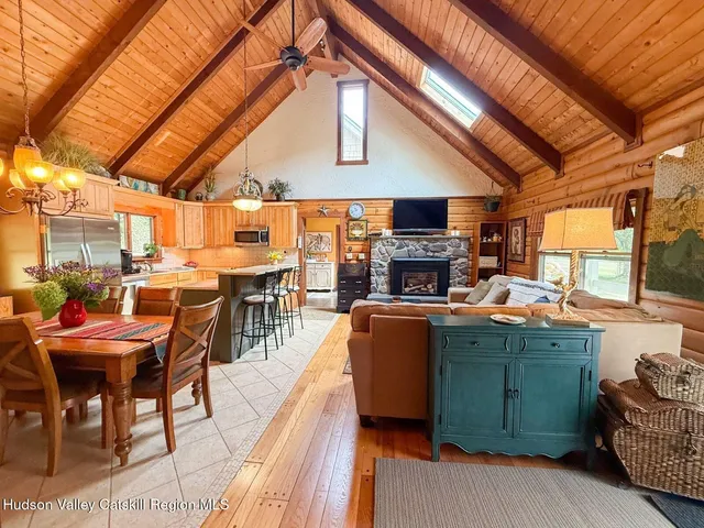 a kitchen with stainless steel appliances kitchen island granite countertop a table chairs in it and wooden floors