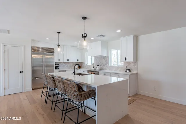 a kitchen with kitchen island a sink stove and refrigerator