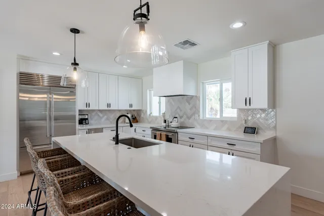 a kitchen with kitchen island a sink and appliances