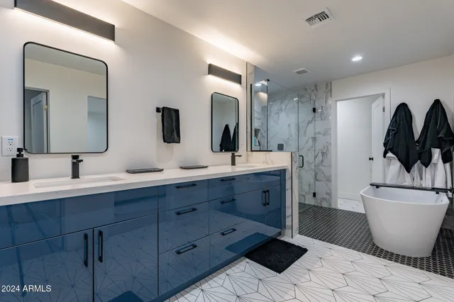 a bathroom with a double vanity sink a mirror and a bathtub