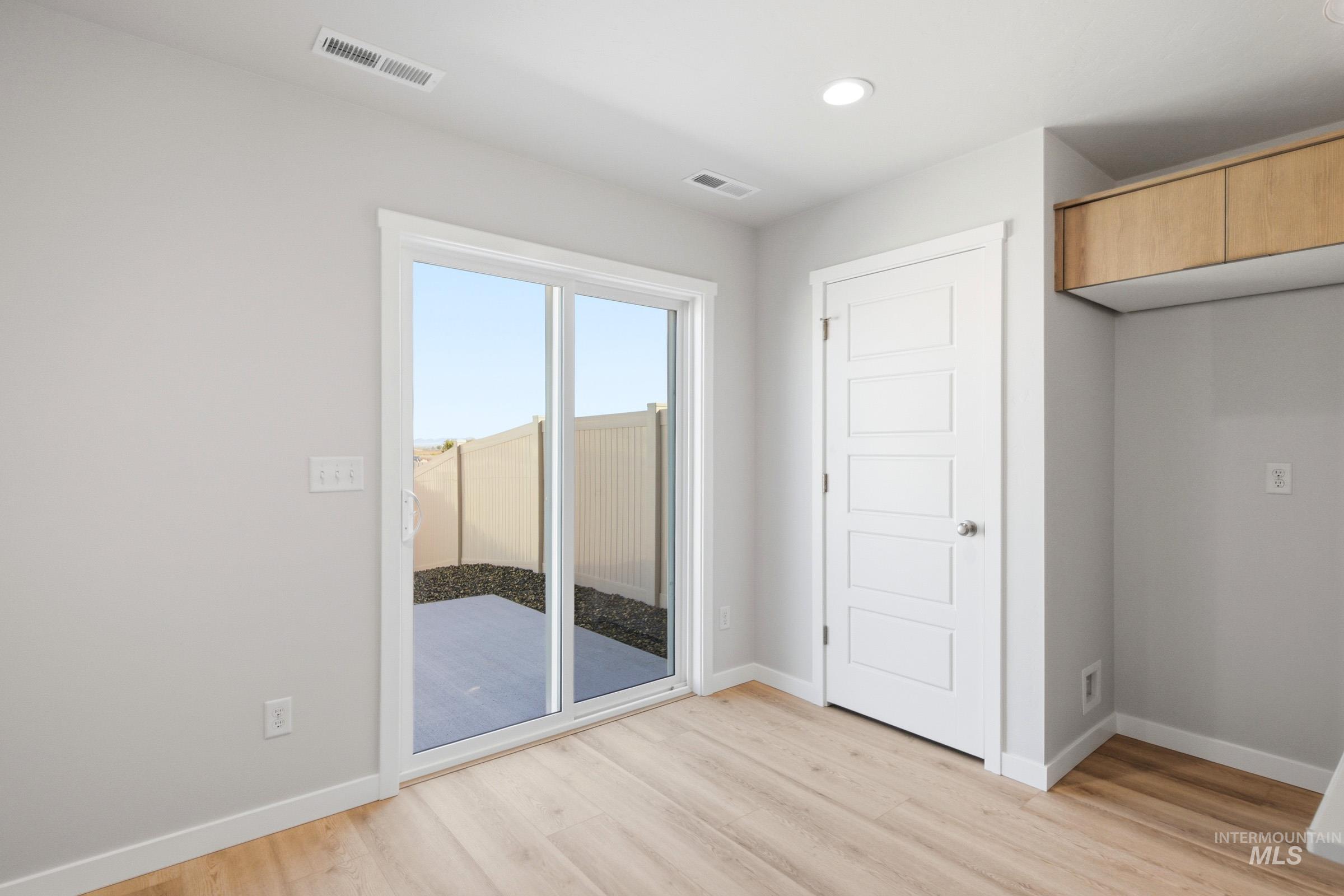 10812 Rutland Street Caldwell, ID 83605 - Photo 9 of 21 Sliding glass door opening to an outdoor patio with rock landscaping and a privacy fence
