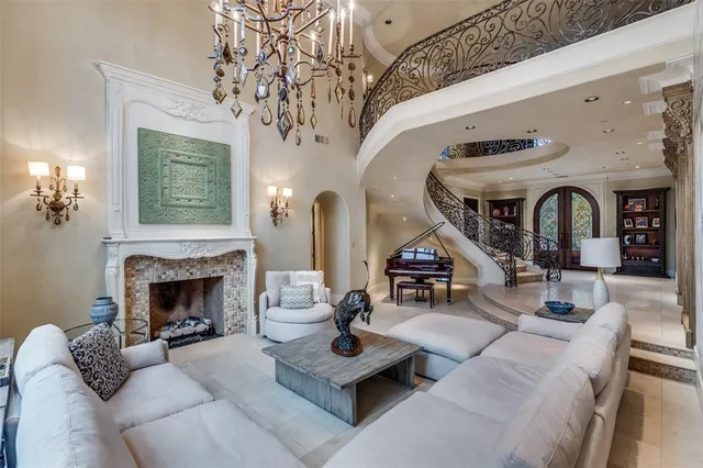 a living room with furniture a fireplace and a chandelier