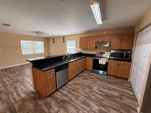 a kitchen with kitchen island granite countertop a sink counter top space and appliances