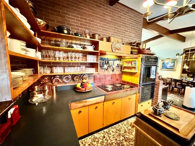 a room with stainless steel appliances kitchen island granite countertop a sink and cabinets