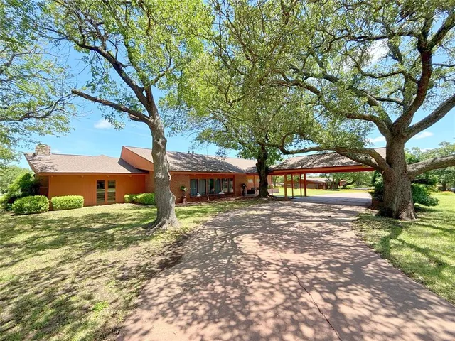 a tree in front of a white house