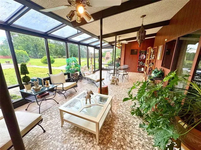 a living room with patio furniture and a floor to ceiling window