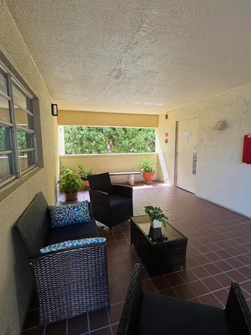 a living room with furniture and a floor to ceiling window