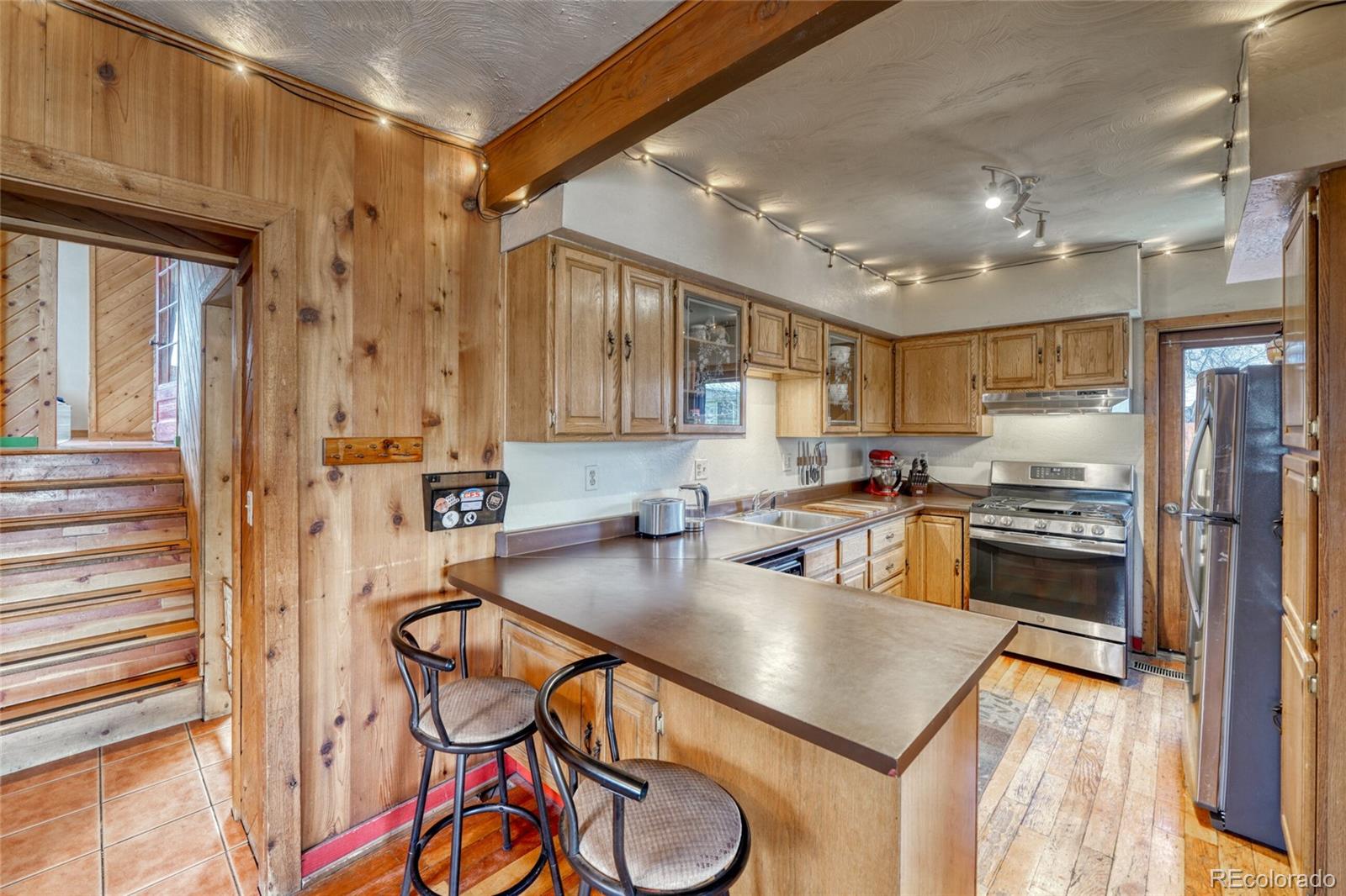 1335 F Street Salida, CO 81201 - Photo 11 of 44 a kitchen with stainless steel appliances granite countertop a table chairs stove and refrigerator