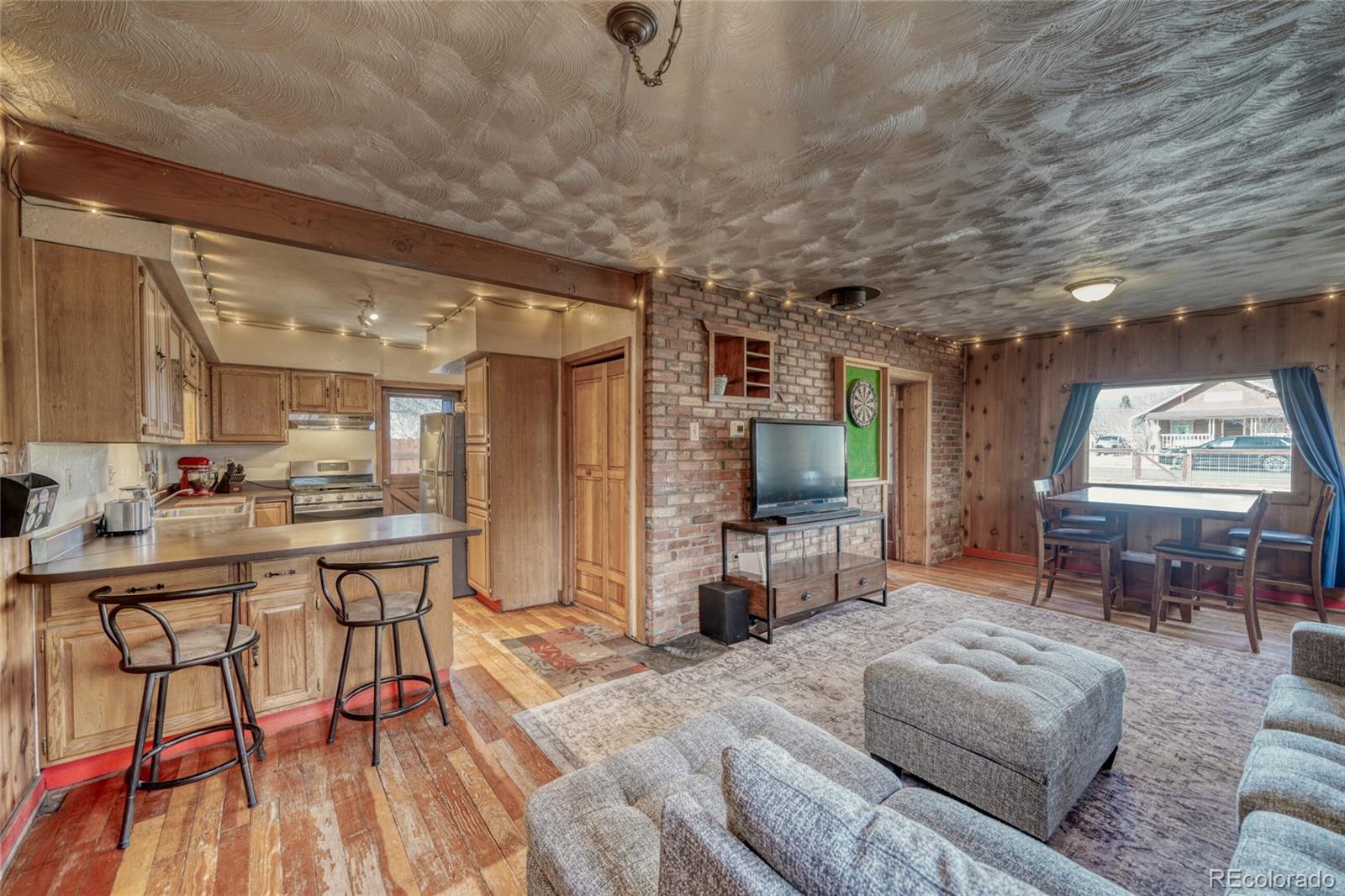 1335 F Street Salida, CO 81201 - Photo 10 of 44 a living room with furniture a flat screen tv and a large window