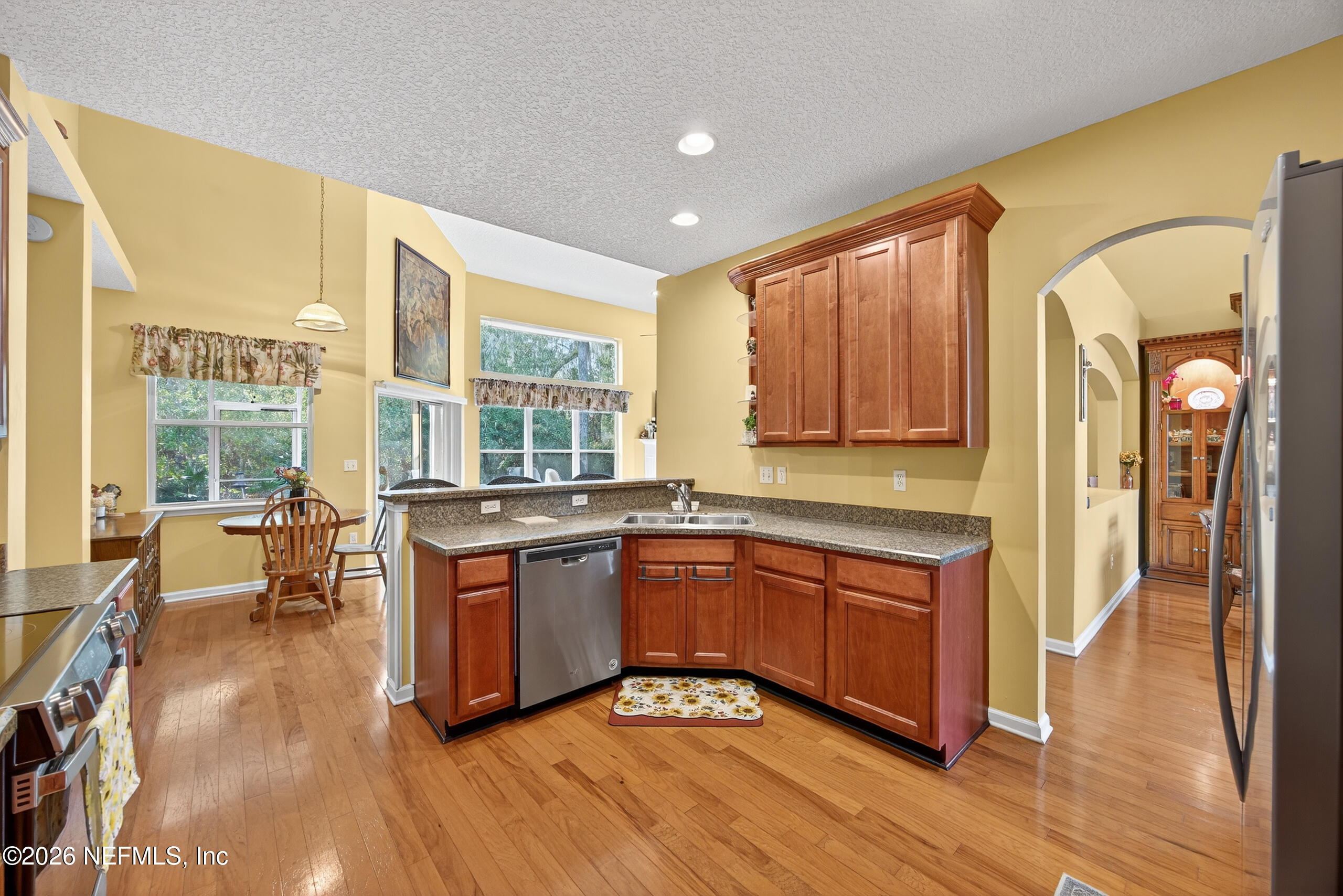 588 Reflection Cove Road Jacksonville, FL 32218 - Photo 16 of 53 a kitchen with stainless steel appliances granite countertop a stove a sink dishwasher and a refrigerator with wooden floor